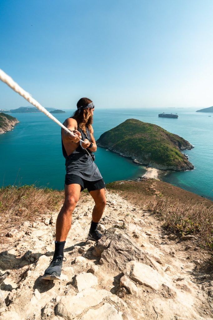 a man holding a baseball bat on top of a hill.