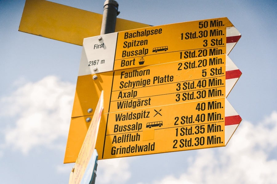 a yellow street sign sitting on the side of a road.