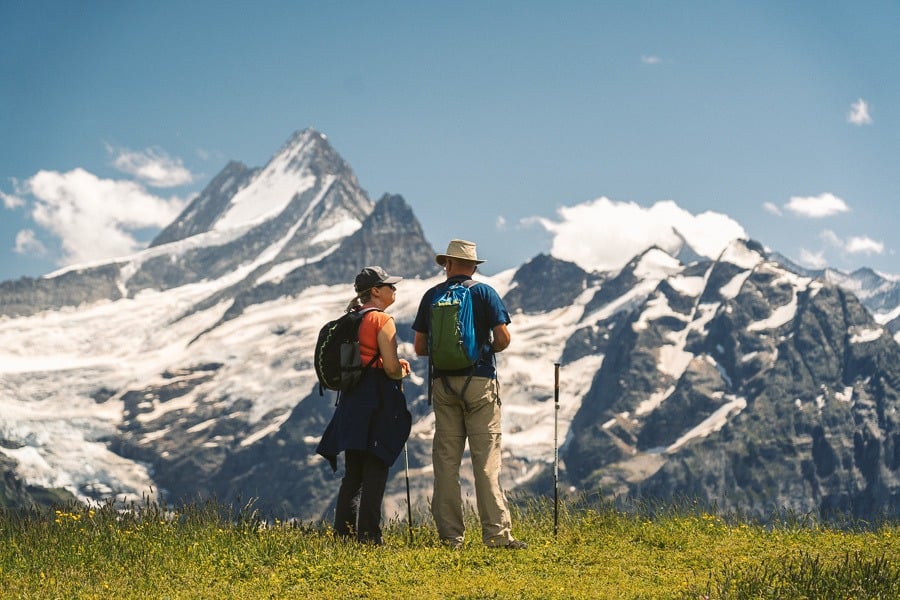 a couple of people standing on top of a grass covered field.