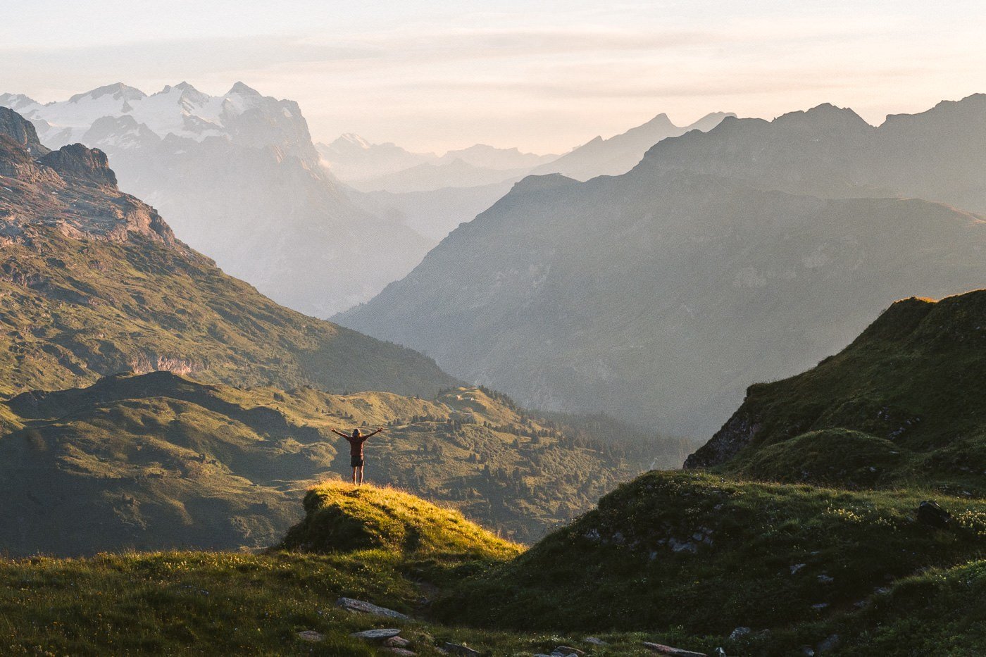 a person standing on top of a green hill.
