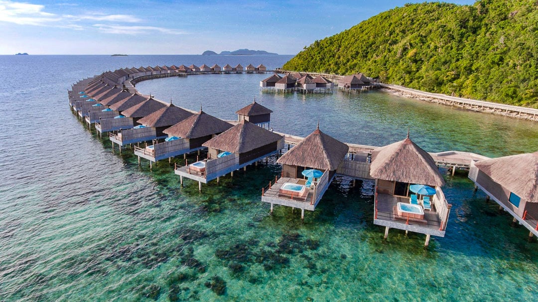a group of huts sitting on top of a body of water.