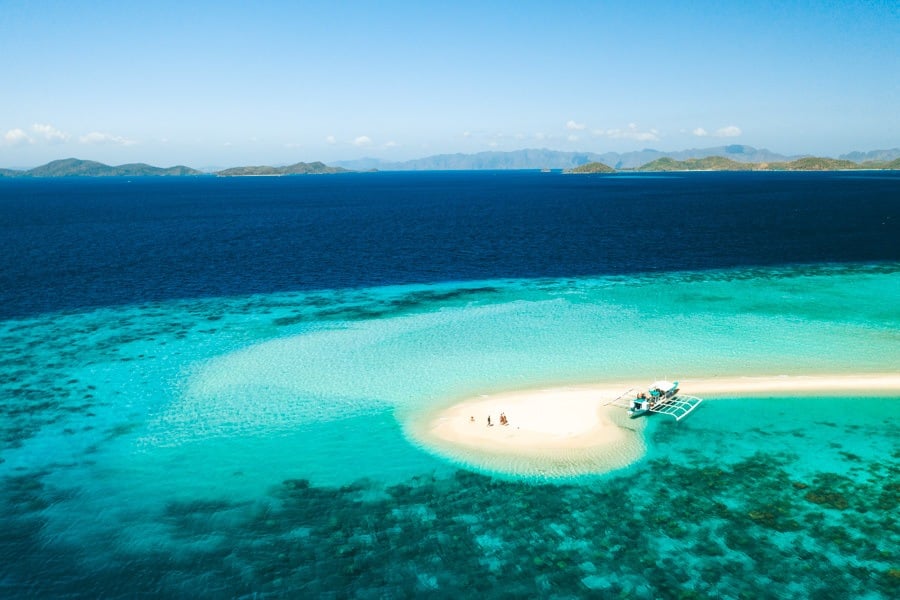 a small boat on a small island in the middle of the ocean.