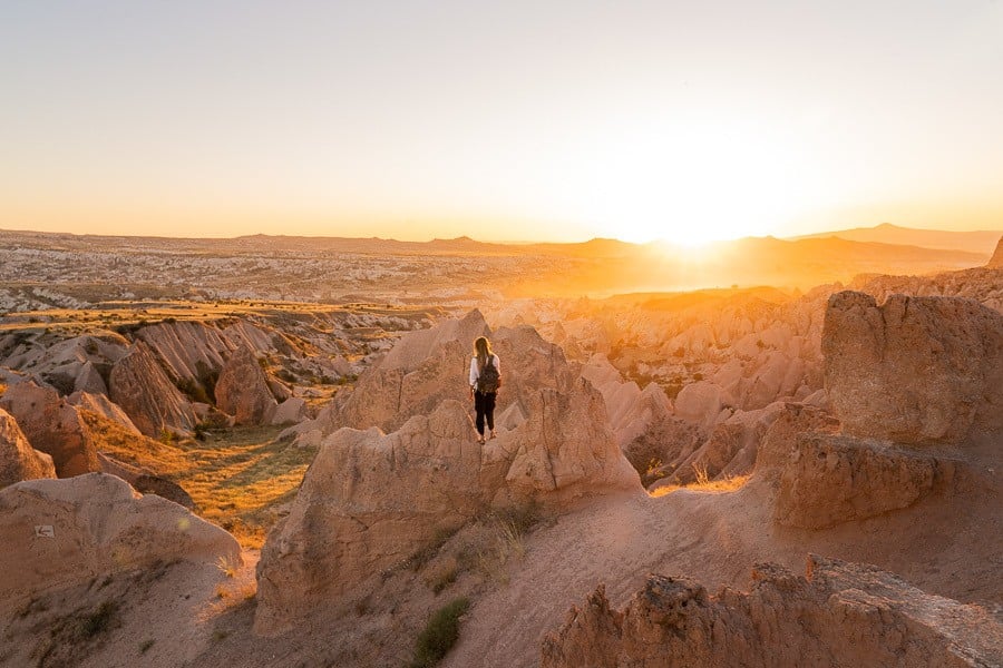 a person standing on top of a rock formation.