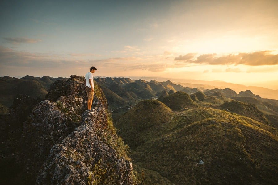 a man standing on top of a mountain.