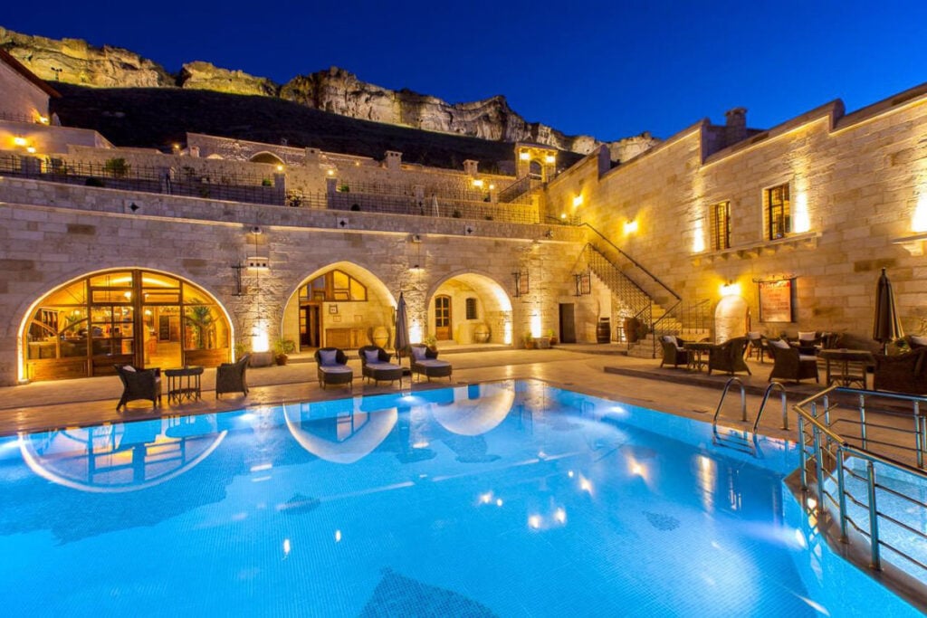 a large swimming pool in front of a stone building