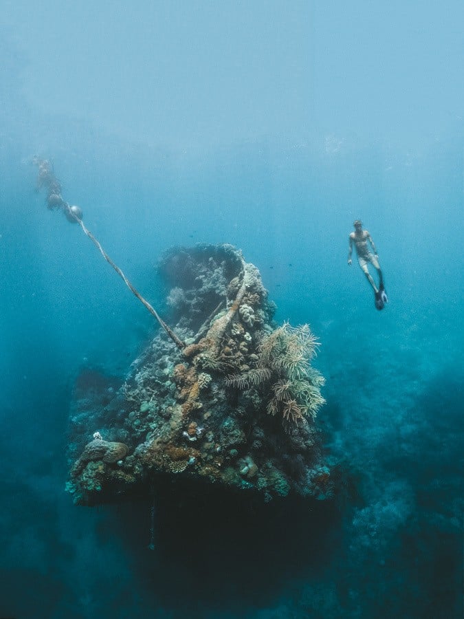 a person swimming in the ocean with a rope.