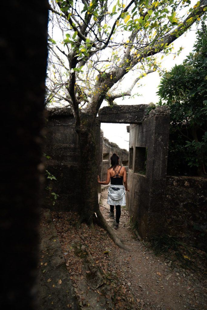 a woman in a white dress walking down a path.