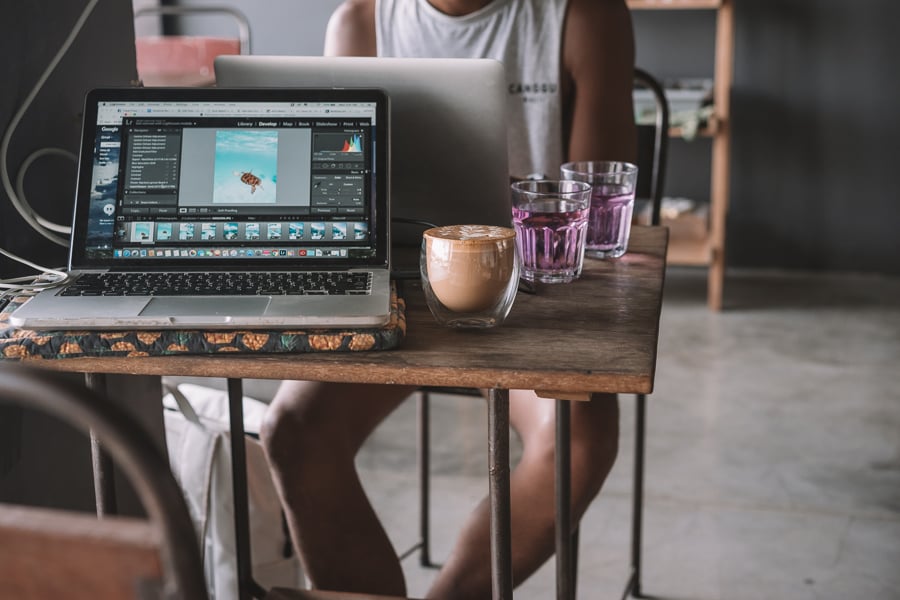 a person sitting at a table with a laptop.