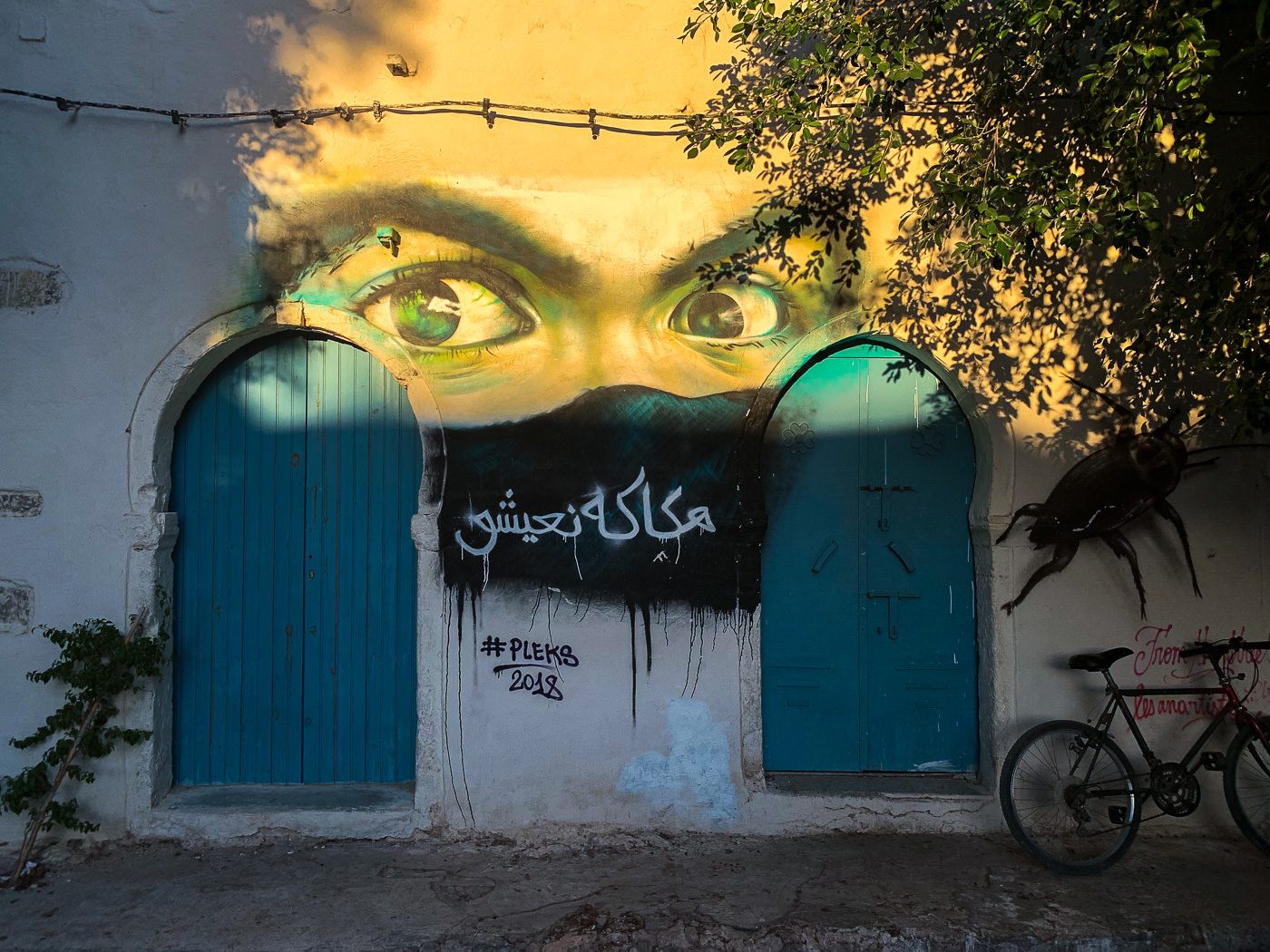 a bicycle parked in front of a building with graffiti on it.