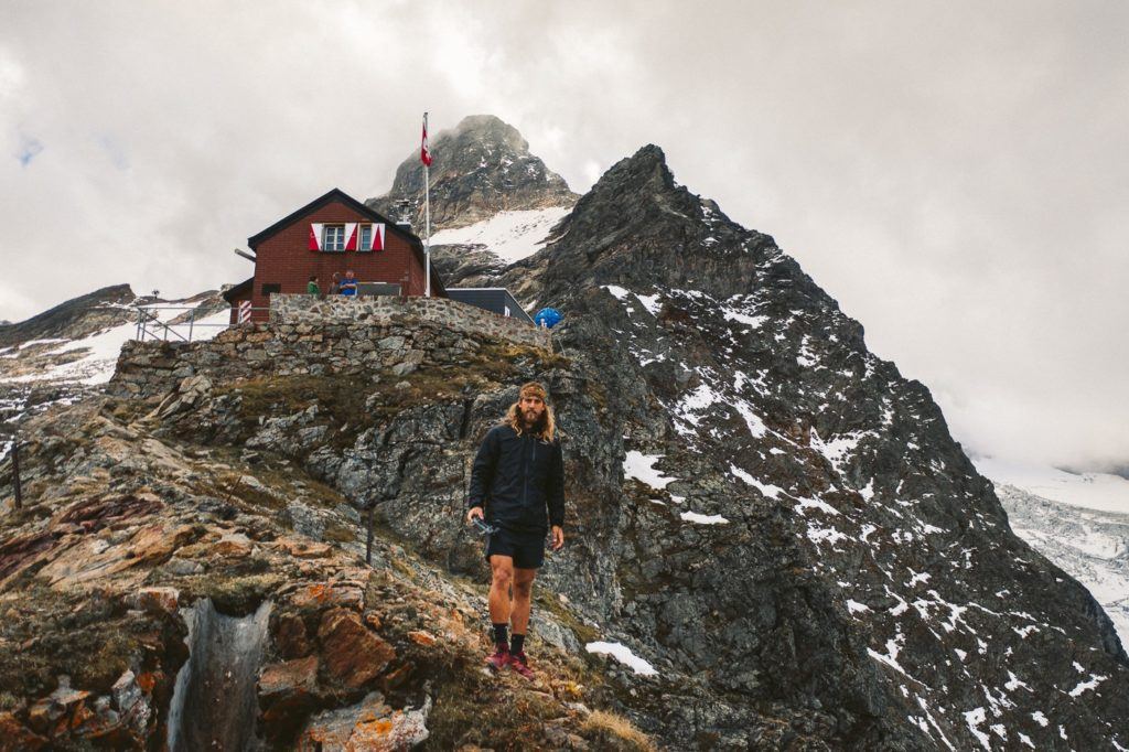 a woman standing on top of a rocky mountain.