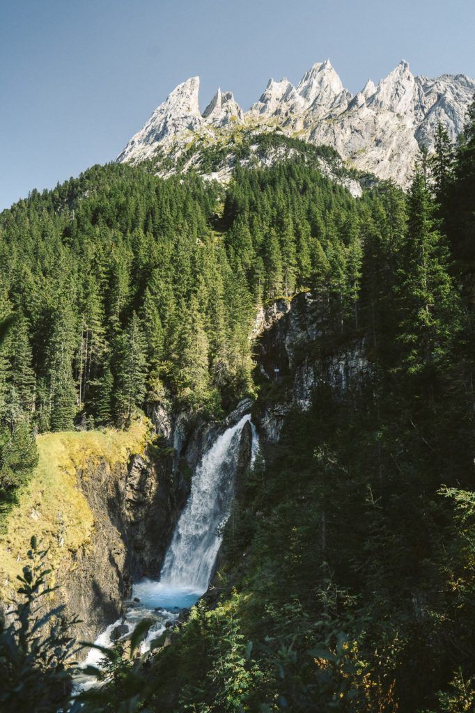 a waterfall in the middle of a lush green forest.