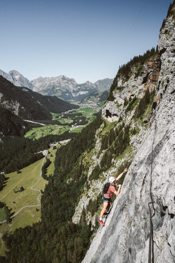a man climbing up the side of a mountain.