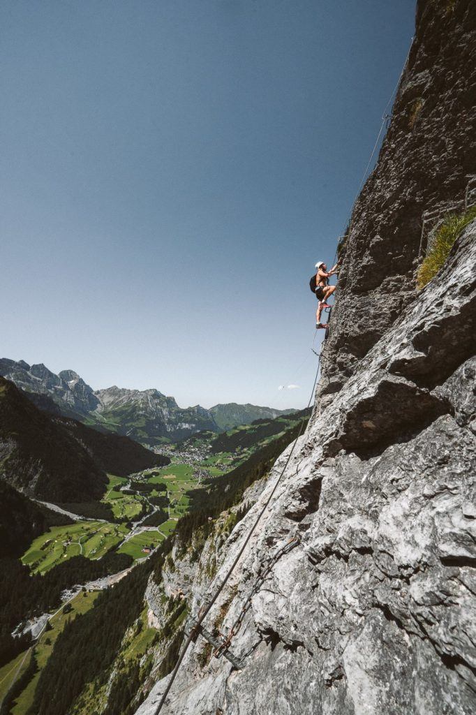 a man on a rock climbing up a steeple.