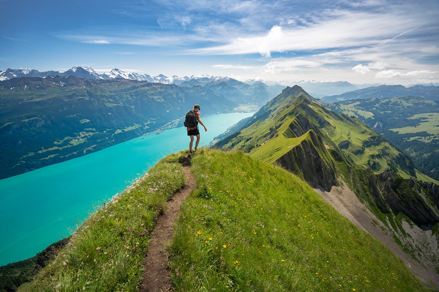 a man standing on top of a grass covered hill. hiking quotes and captions for instagram