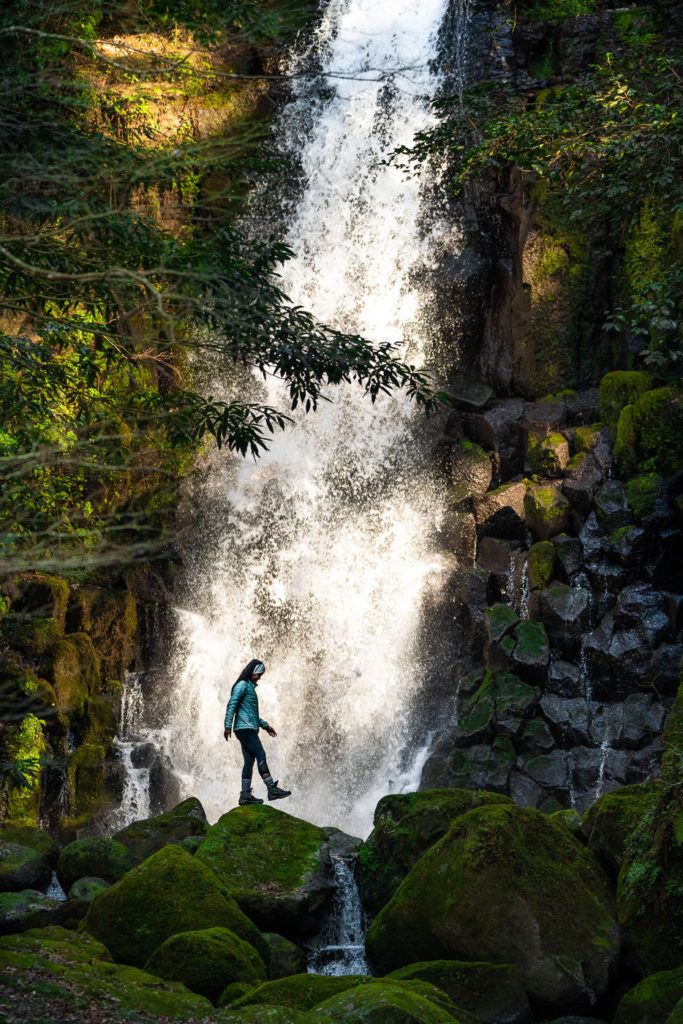 a person standing in front of a waterfall.