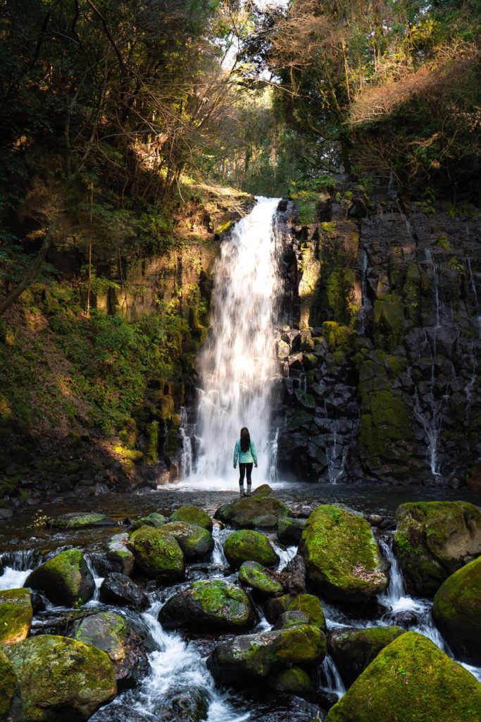 a person standing in front of a waterfall.