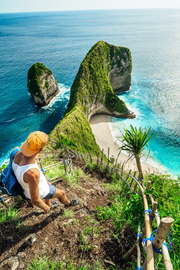 a woman sitting on a hill overlooking the ocean.