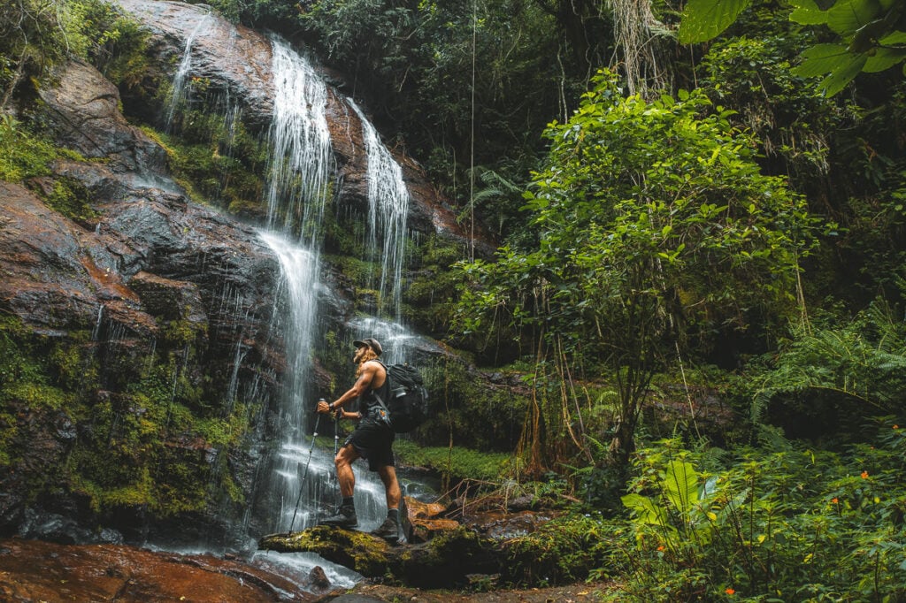 a man standing in front of a waterfall