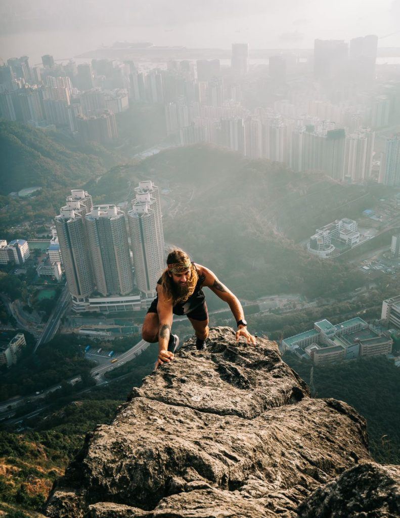 a man standing on top of a large rock.