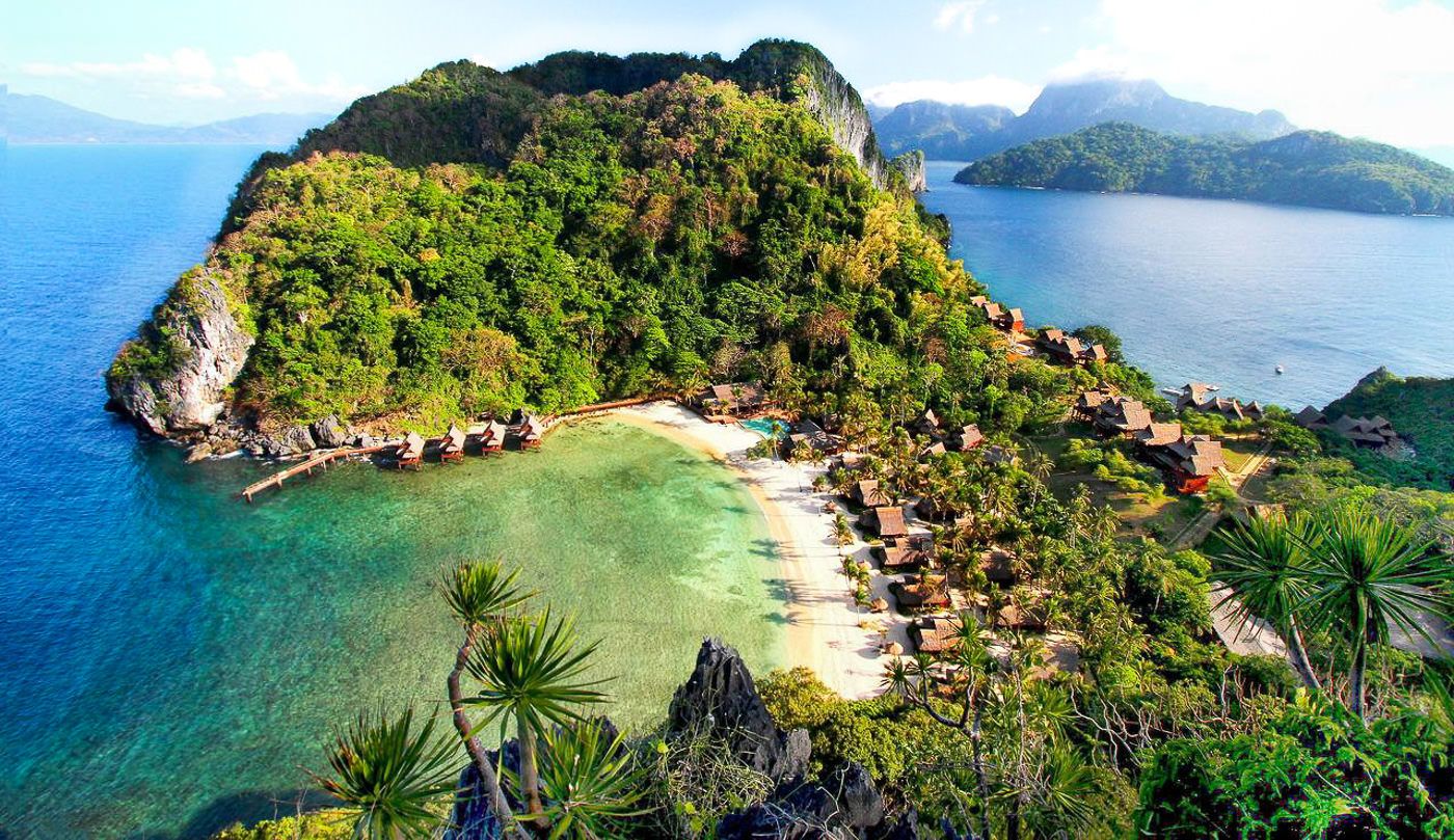 an island with a sandy beach and some trees.