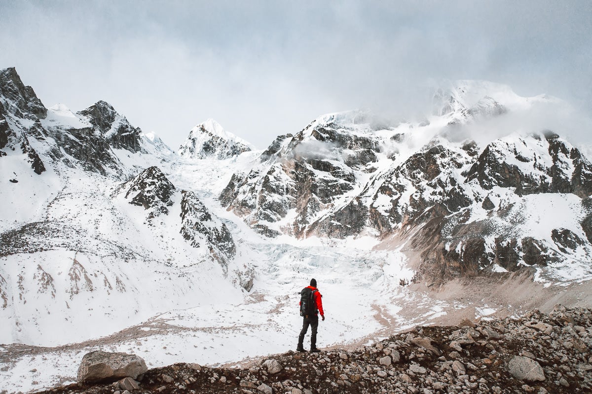 a man standing on top of a snow covered mountain