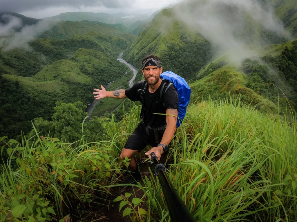 a man with a backpack on top of a mountain
