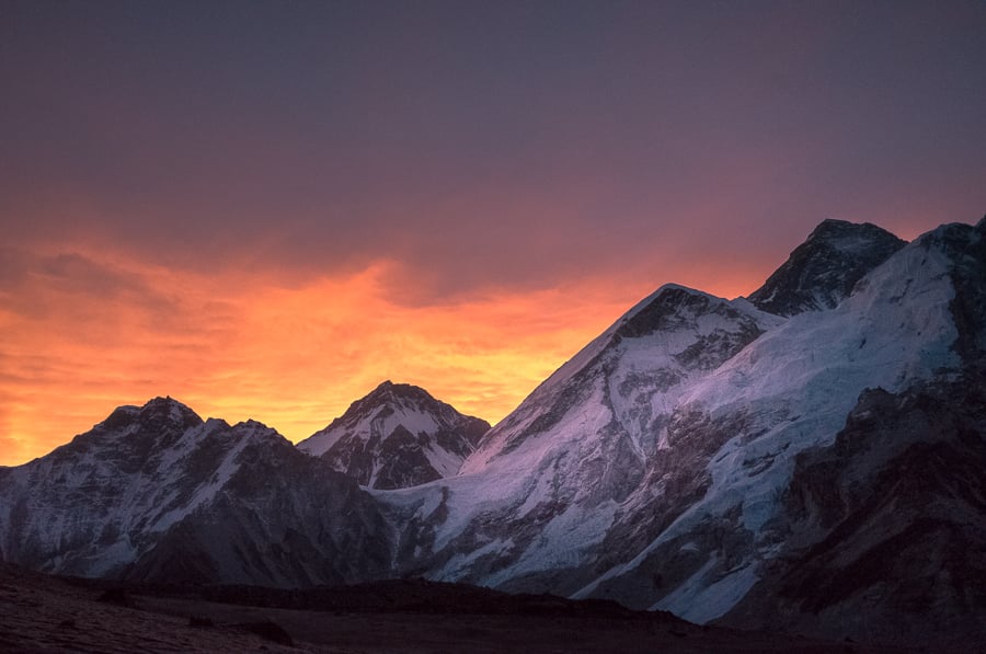 the sun is setting behind a mountain range.