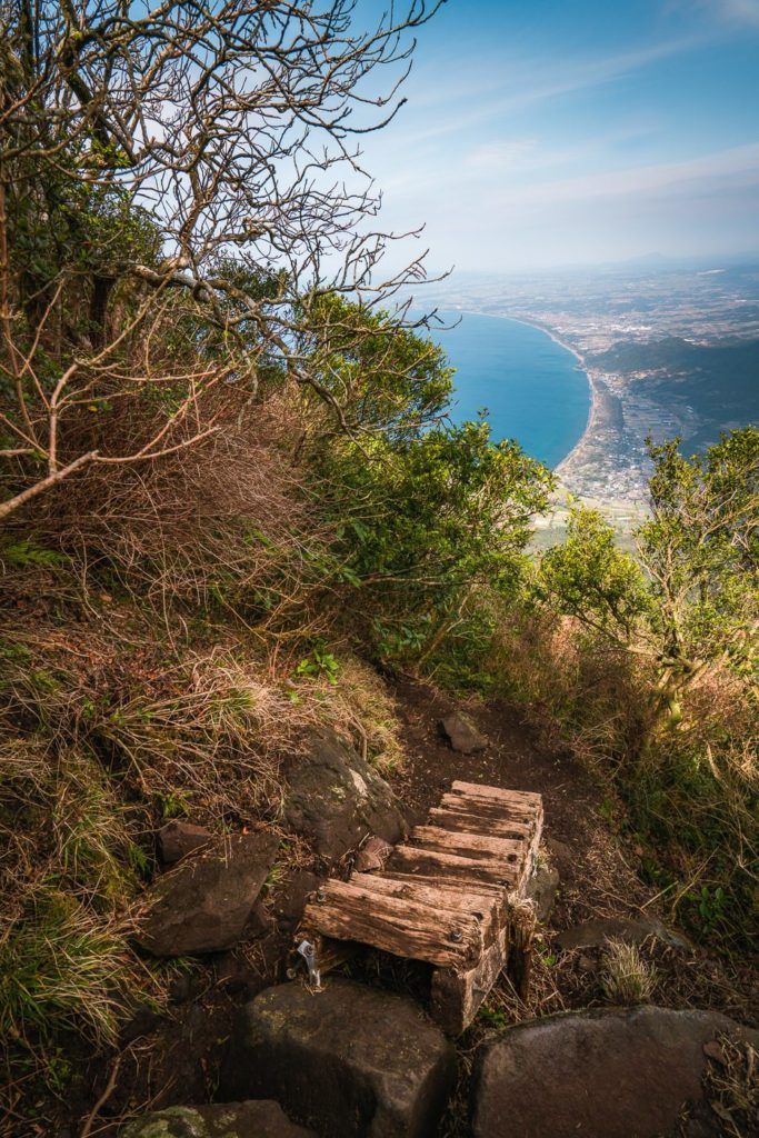 a wooden bench sitting on top of a rocky hill.