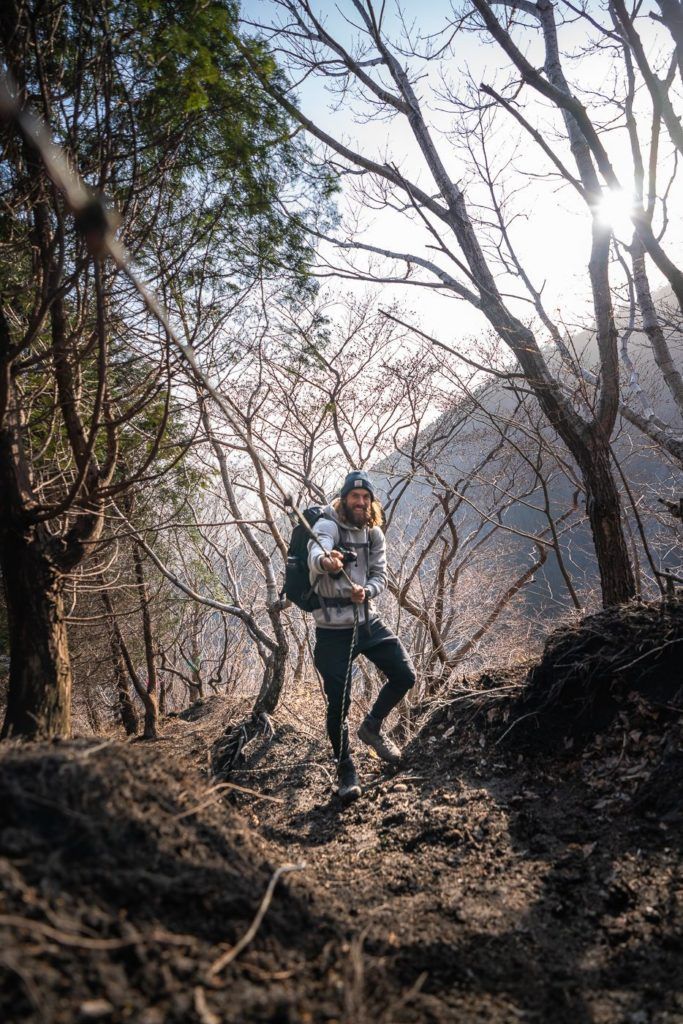 a man and a woman standing in the woods.