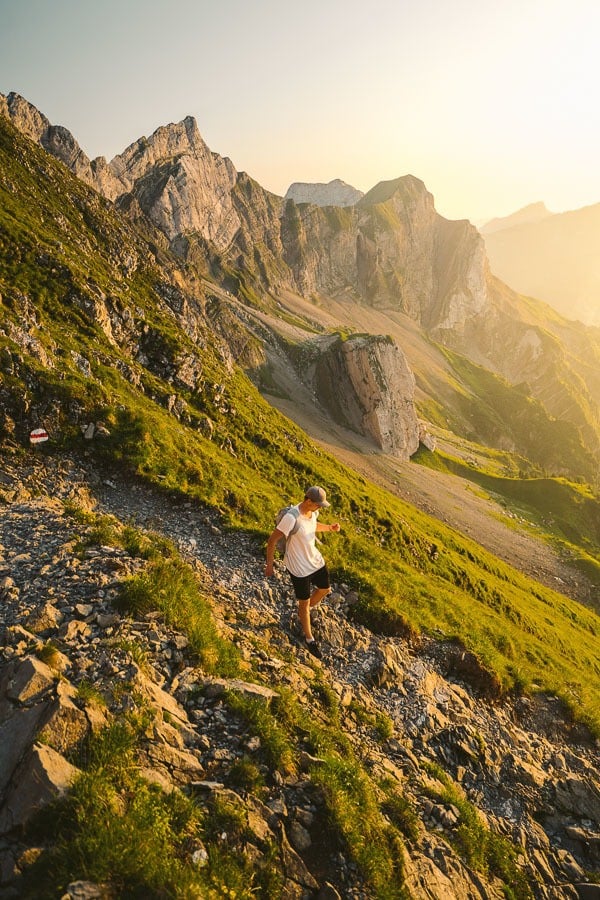 a person is flying a kite on a mountain.