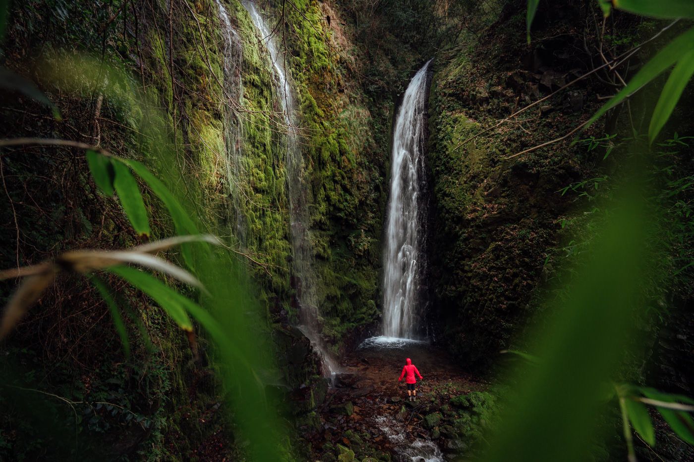 a person standing in front of a waterfall.