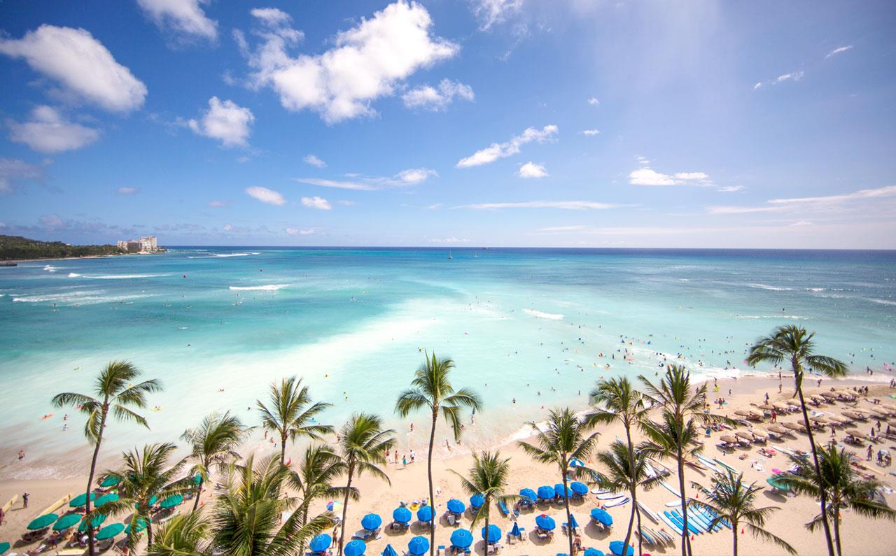 a beach filled with lots of people and umbrellas.