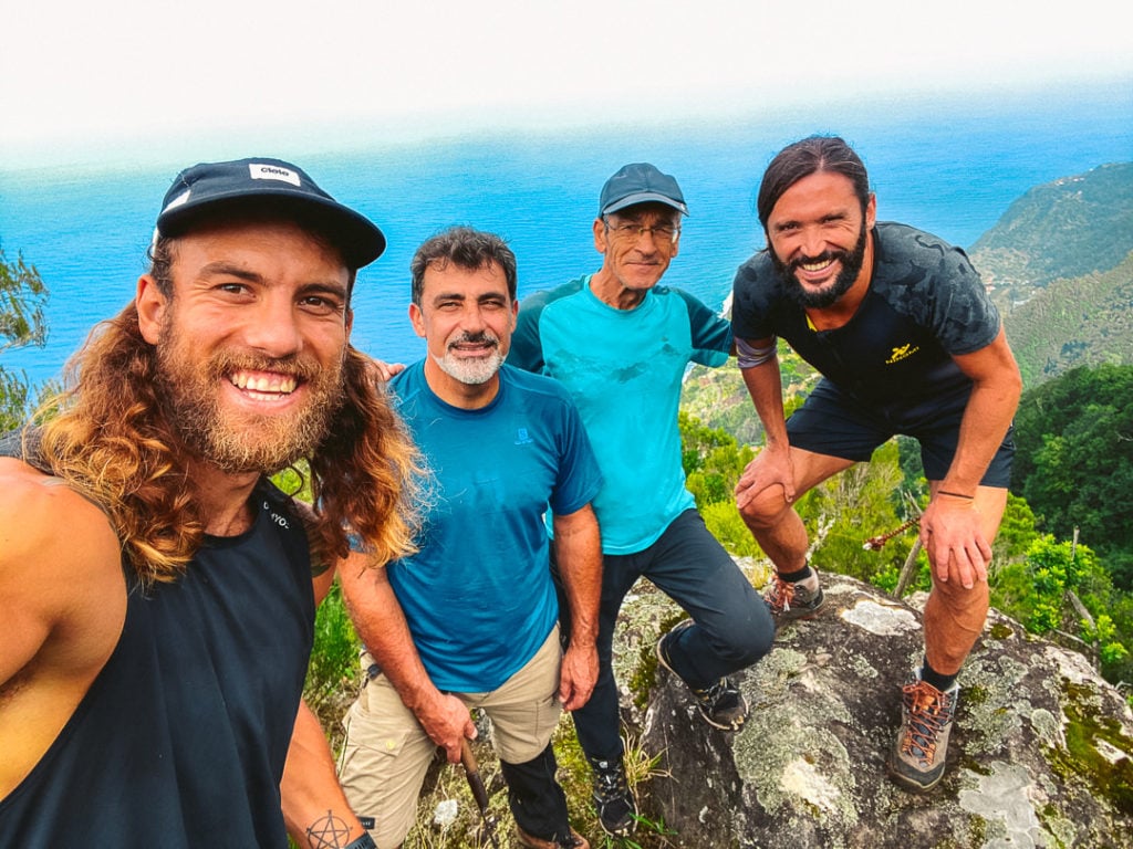 a group of men standing on top of a mountain.