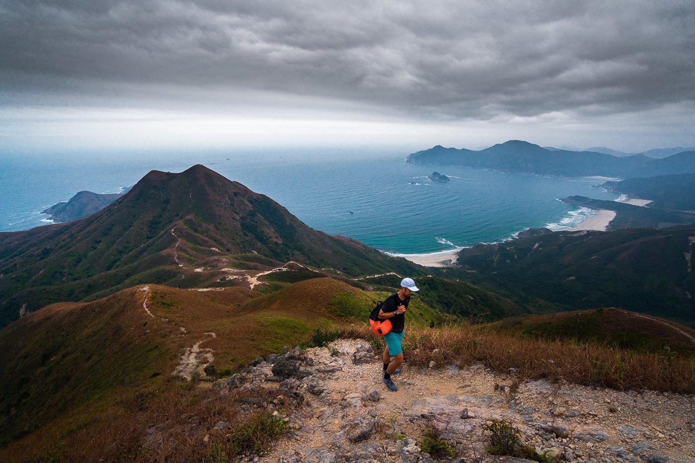 a person standing on a mountain looking at the ocean.
