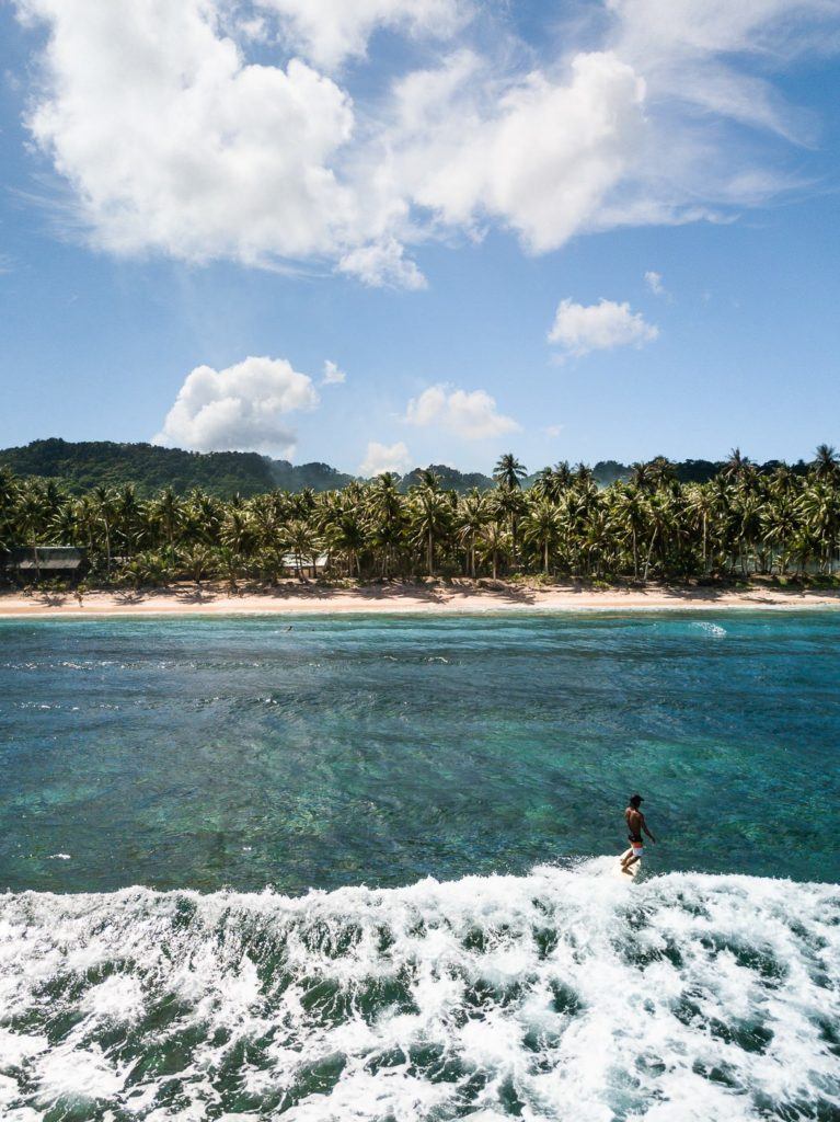 a man riding a surfboard on top of a wave in the ocean.