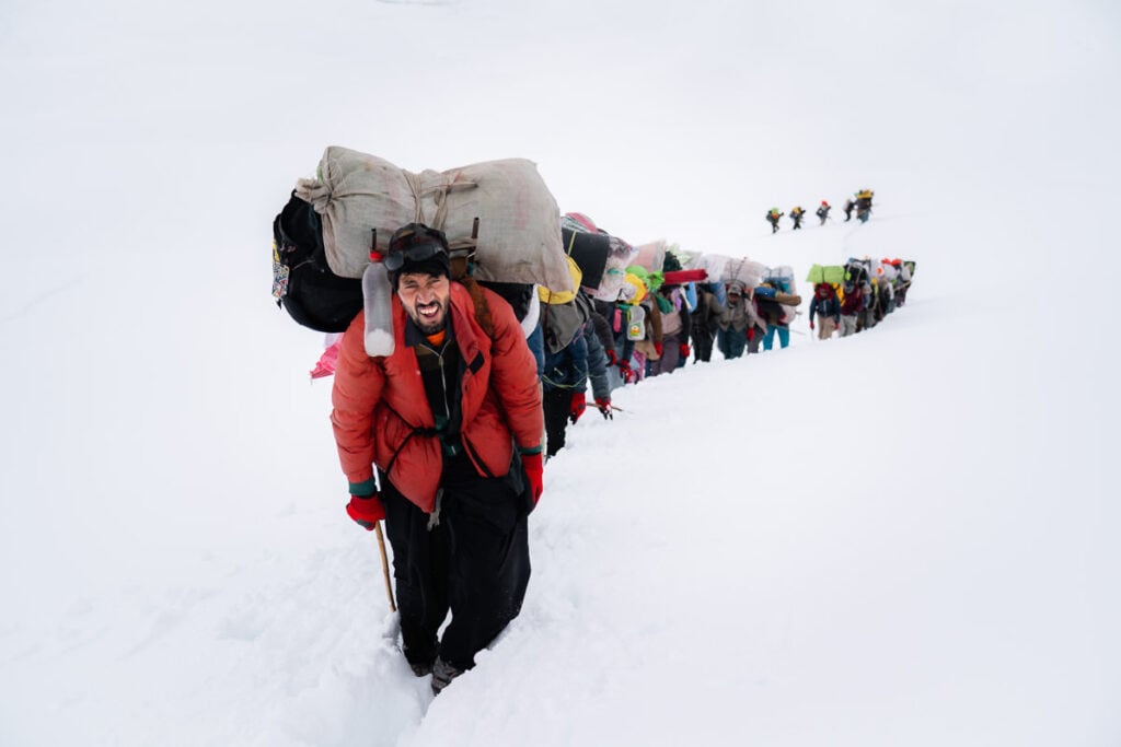 a group of people walking up a snow covered hill