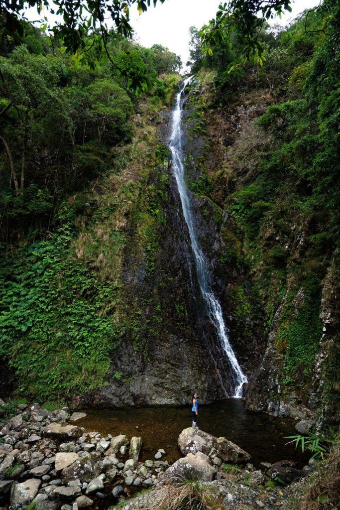 a person standing in front of a waterfall.