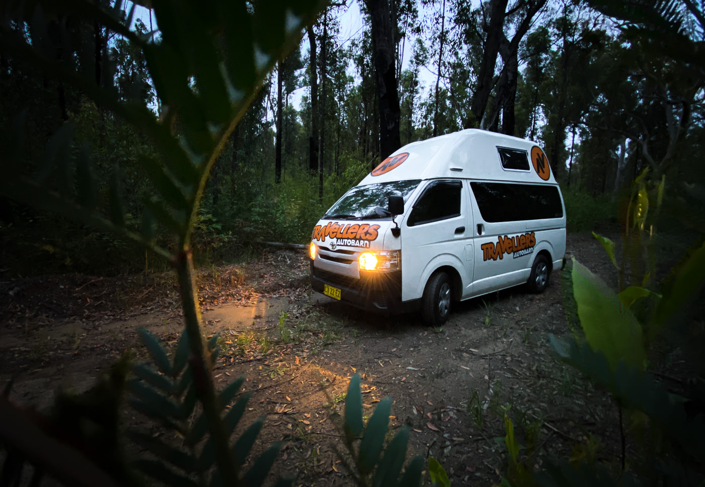 a white van parked in the middle of a forest