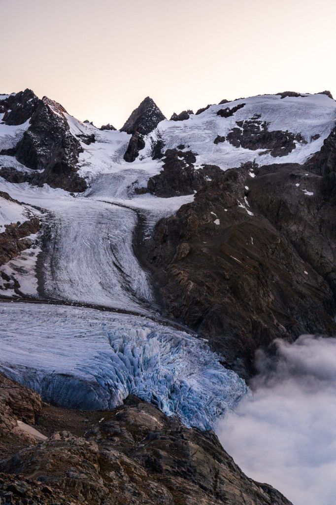 a mountain with a glacier in the foreground.