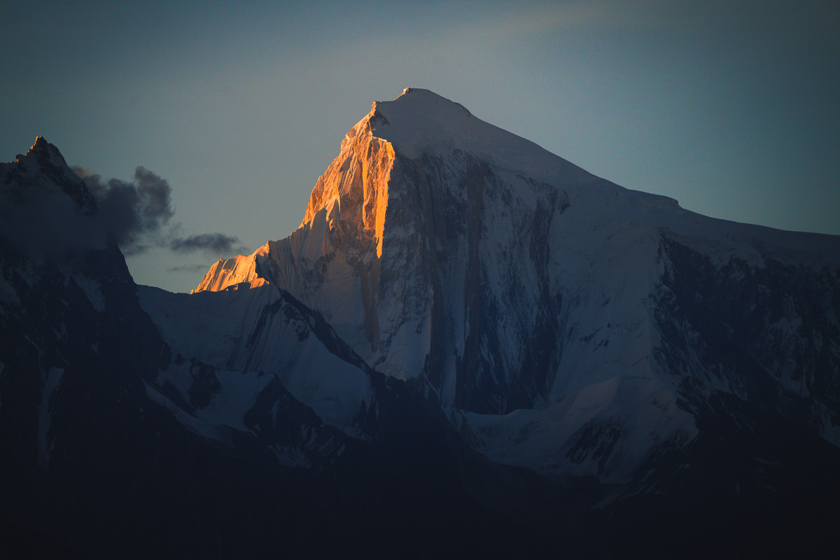 a snow covered mountain with a cloud in the sky