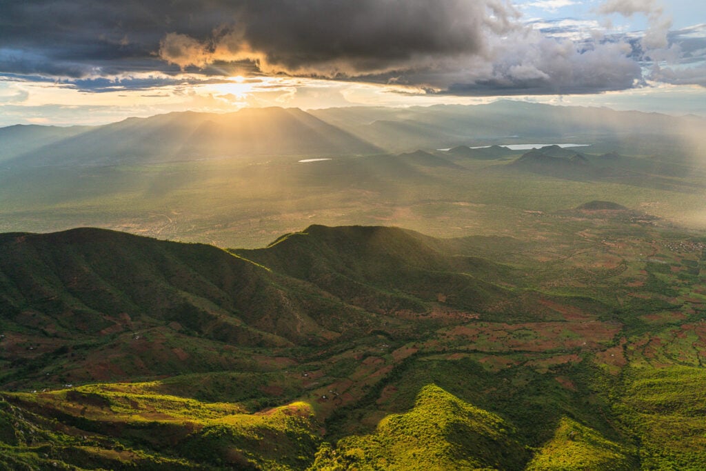 the sun shines through the clouds over the mountains