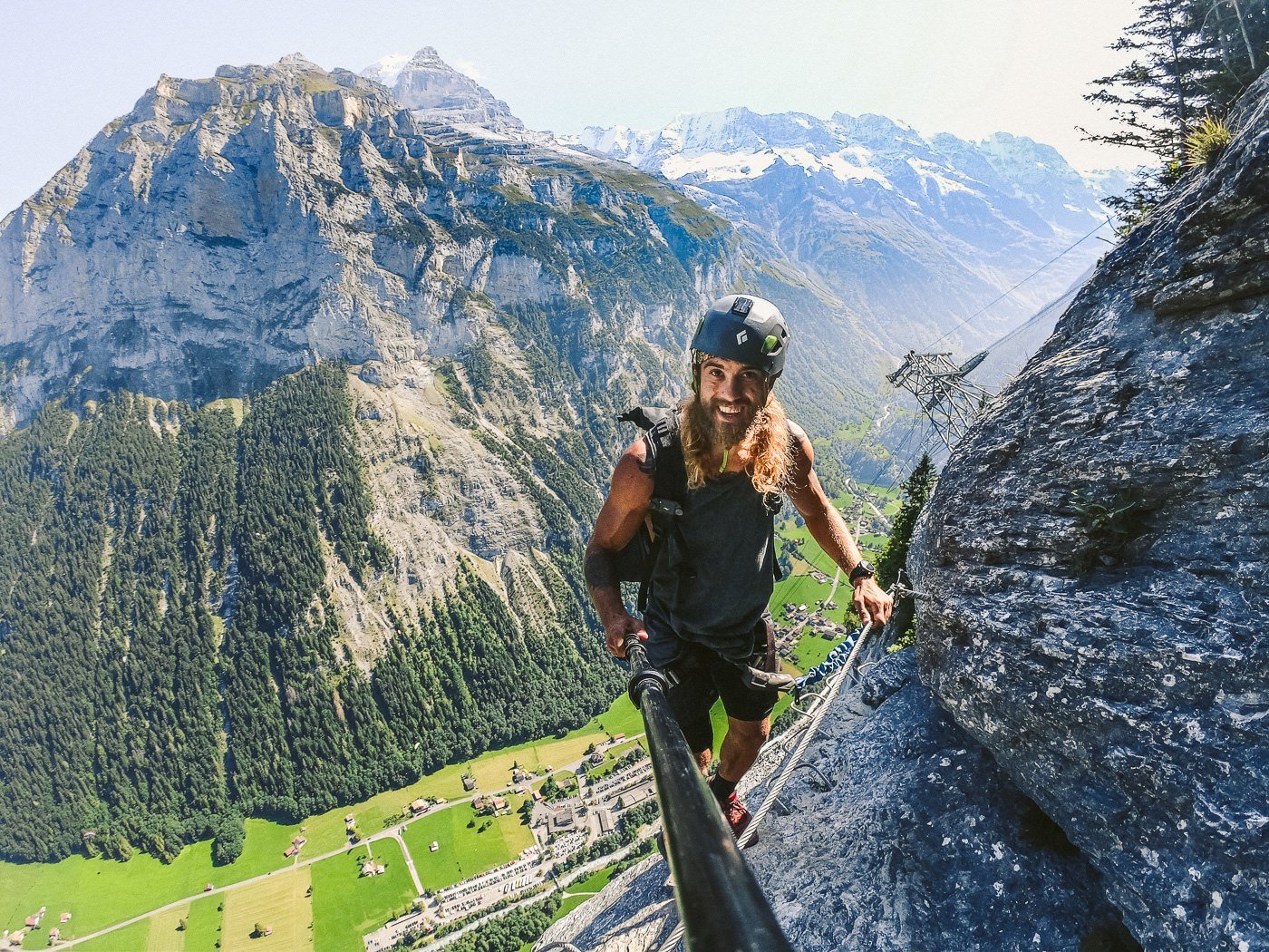 a man climbing up a steeple with a helmet on.