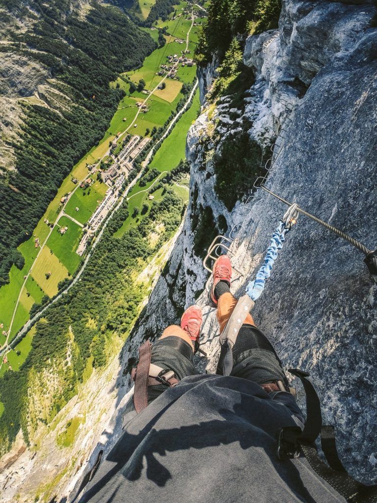 two people standing on top of a cliff.