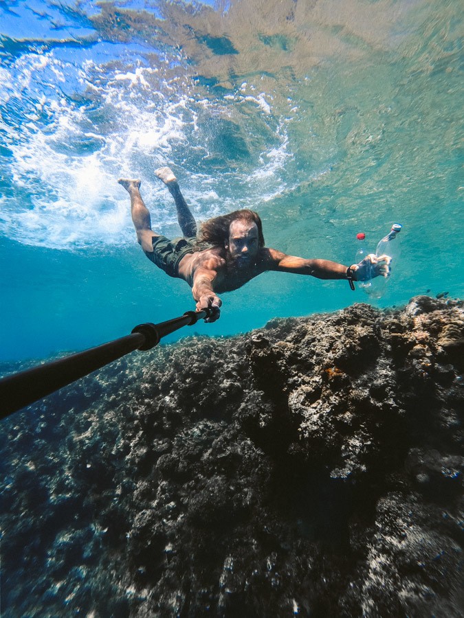 a man swimming in the ocean with a paddle.