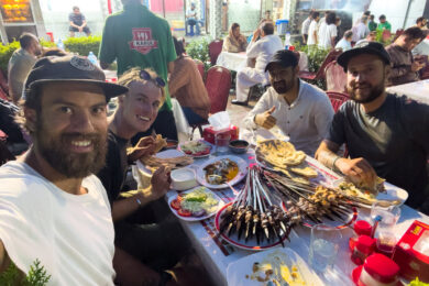 a group of people sitting around a table with food on it