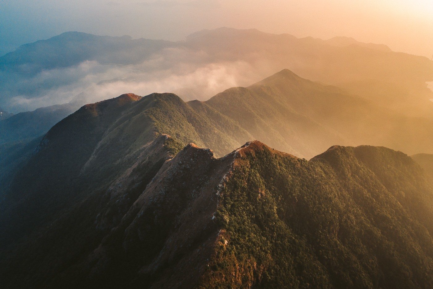 a view of a mountain range with a plane in the sky.