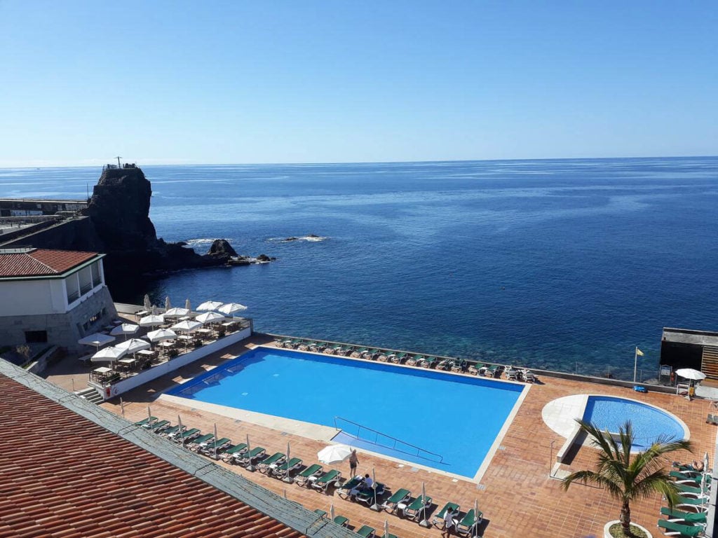a large swimming pool next to the ocean.