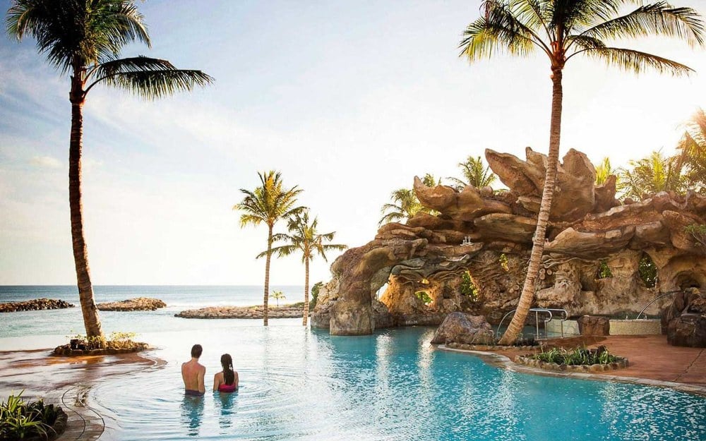 a couple of people sitting in a swimming pool.